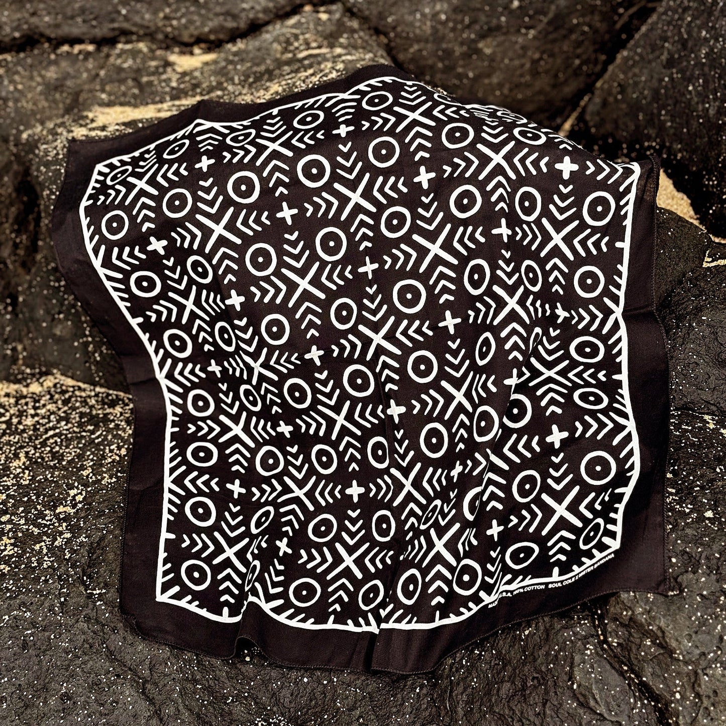 Bandana with black and white mud cloth patterned on a stone surface